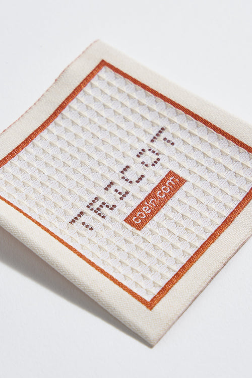 Woven label with worked stitch